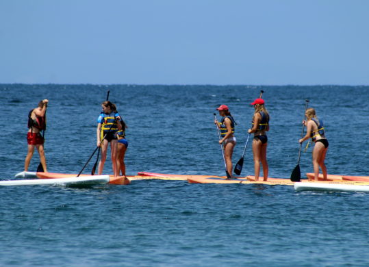 summer campers paddle boarding