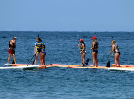 summer campers paddle boarding