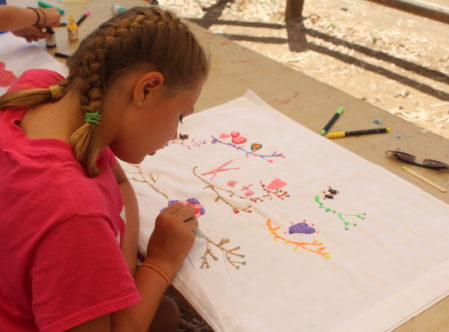 girl at summer camp using fabric marker