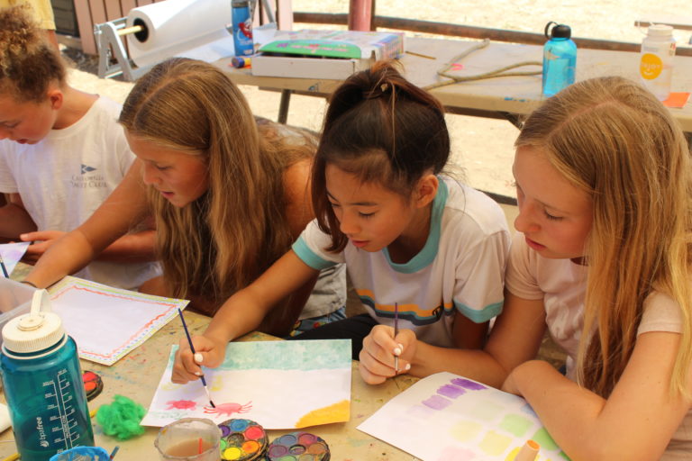 girls learning to paint in class