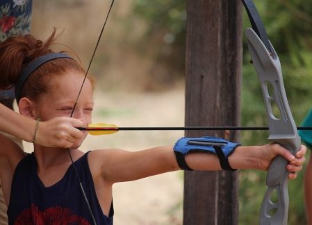 young girl performing archery