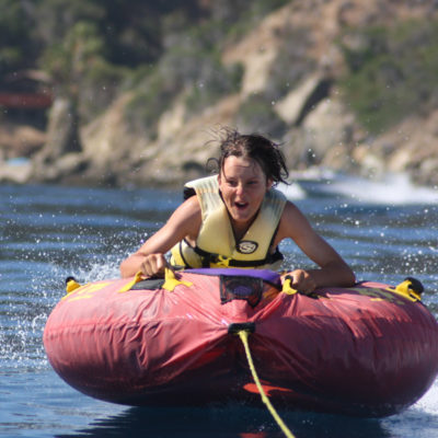 camper being pulled in a tube by a powerboat