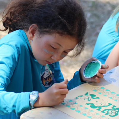 camper painting during arts and crafts time