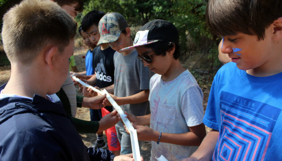 boys trying to send a marble down a series of chutes