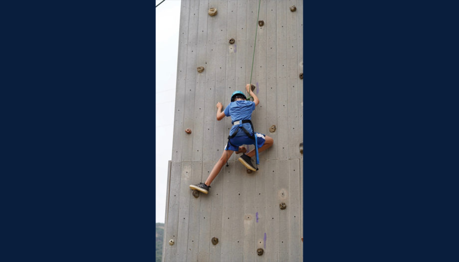 boy on the climbing wall in protective gear