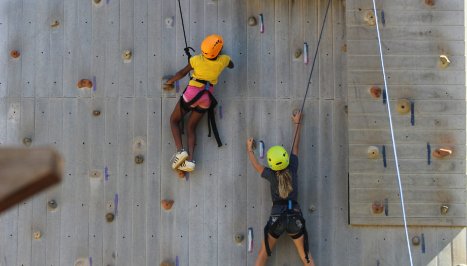 two girls climbing together on the climbing wall