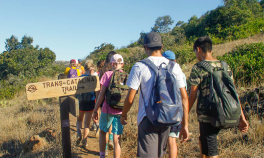 campers hiking past a direction sign