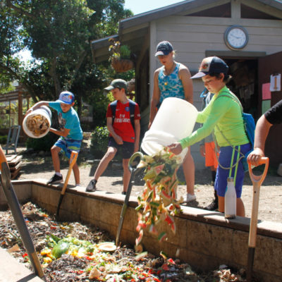campers dumping food waste into the camp compost