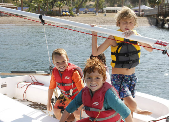 kids in life jacket on boat