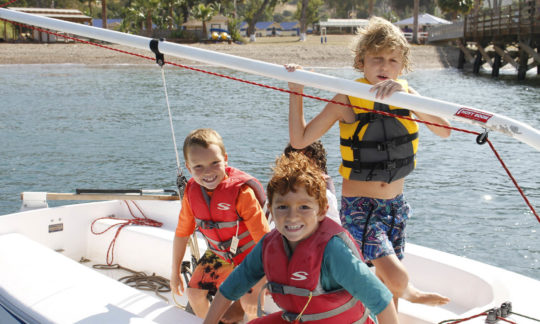 kids in life jacket on boat