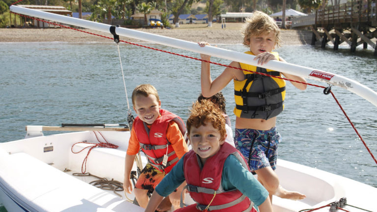 kids in life jacket on boat