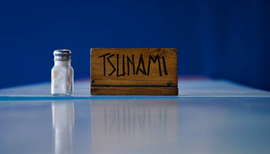 salt shaker on a cafeteria table with a sign for the Tsunami group