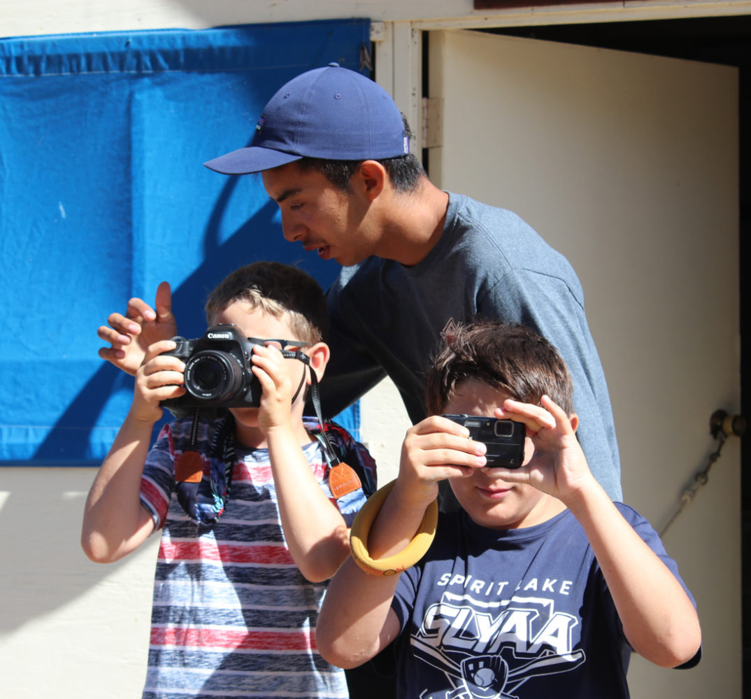 counselor showing campers how to use a DSLR camera