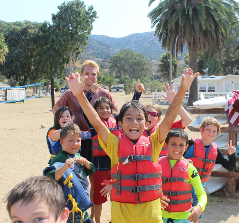 campers smiling with lifejackets on after sailing