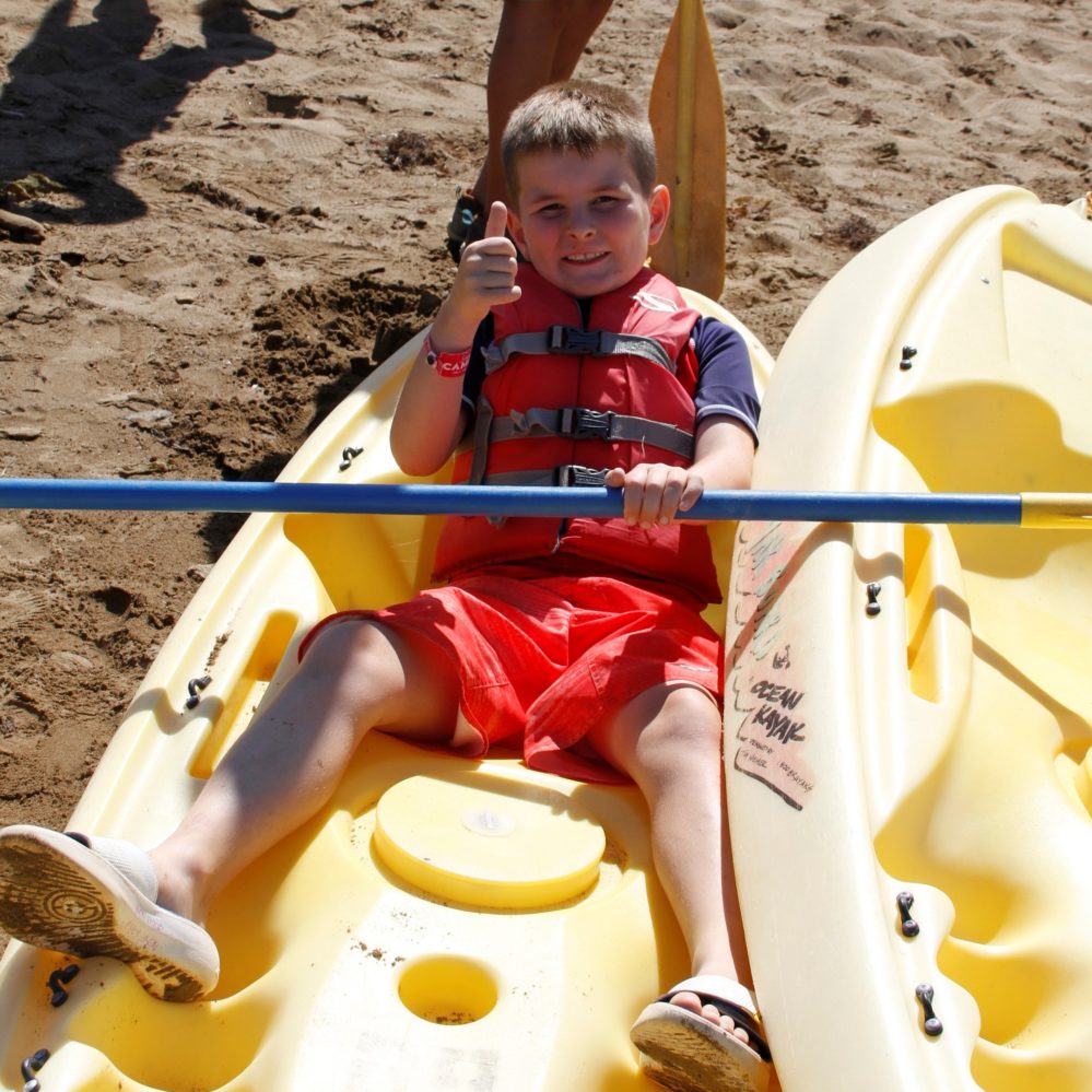 kid wearing lifejacket in kayak