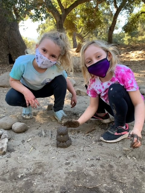 2 girls playing with mud