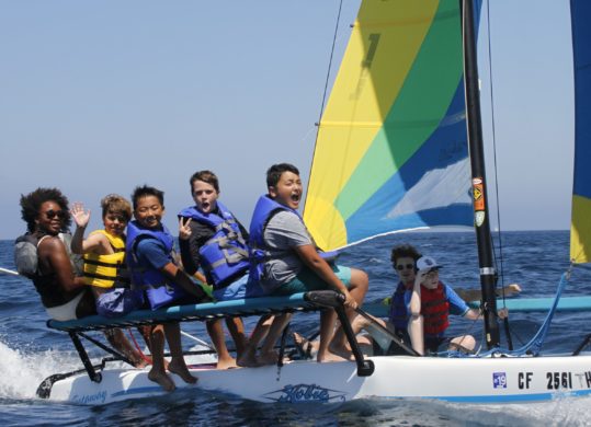 campers and counselors on a catamaran