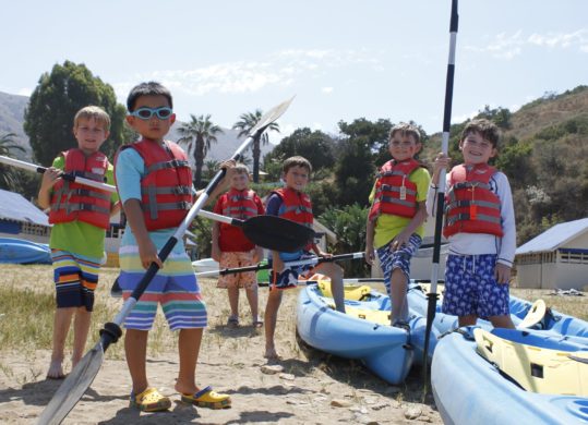 6 boy campers posing with kayak paddles