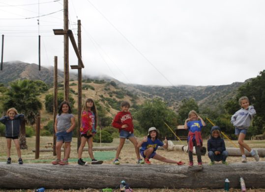 campers posing on a big log