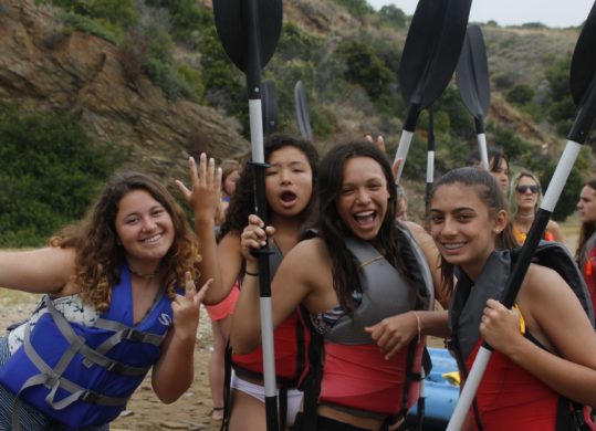 4 girls holding kayak paddles