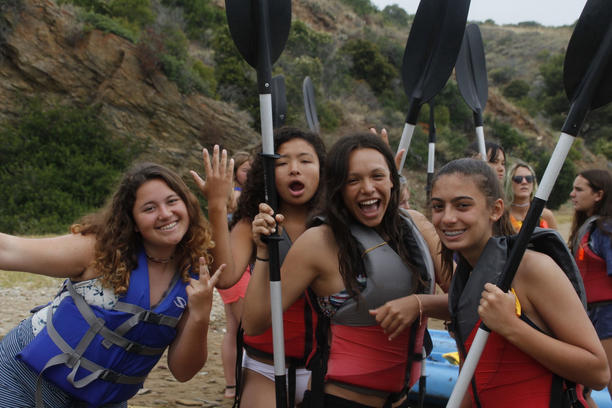 4 girls holding kayak paddles